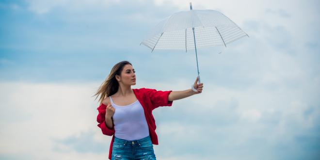 Woman holding up white umbrella