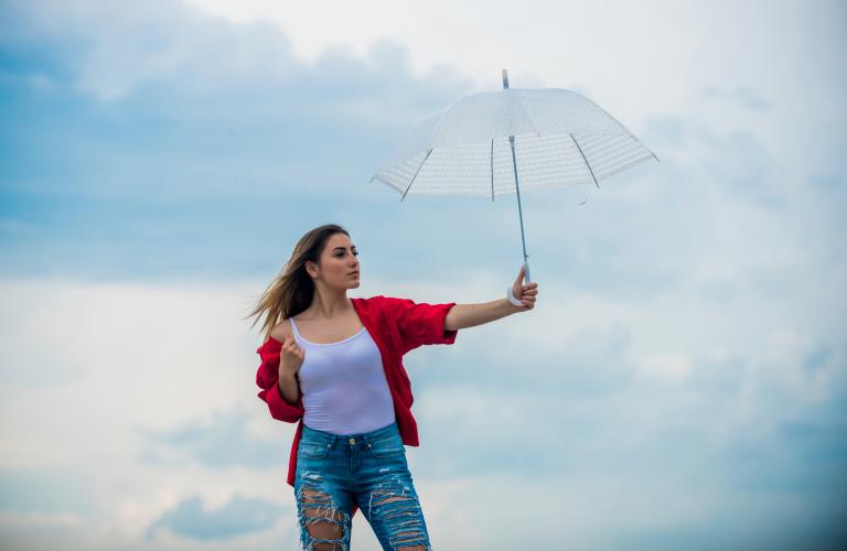 Woman holding up white umbrella